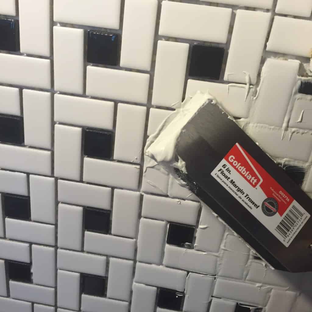 applying grout to tile backsplash