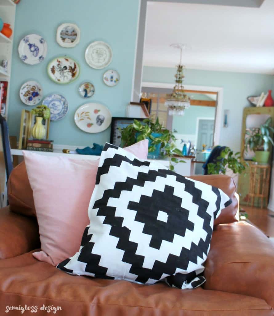 black and white stenciled pillow on leather chair