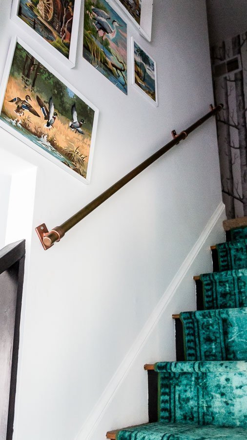 copper handrail and teal runner on stairs