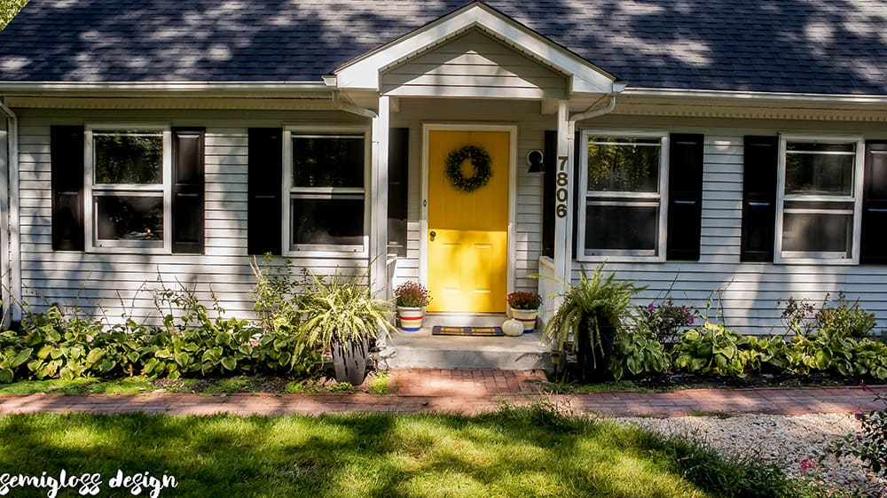 Updated curb appeal picture with yellow front door and black shutters