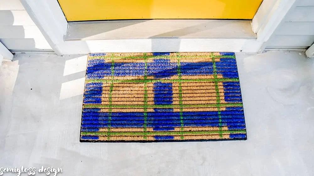 Paint a plaid doormat and elevate your entryway! This easy DIY welcome mat is the perfect seasonal touch to boost your curb appeal on a budget! #curbappeal