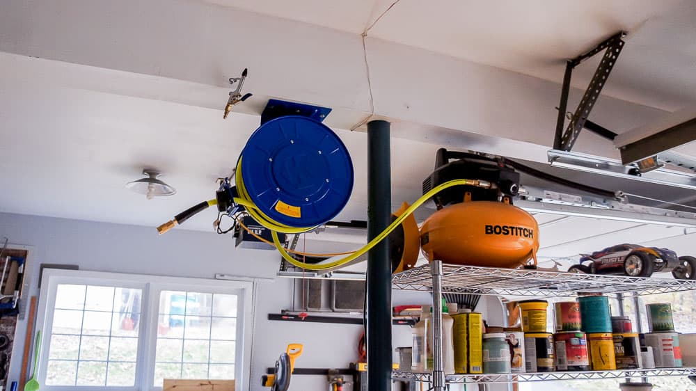 retractable air compressor hose on ceiling in garage