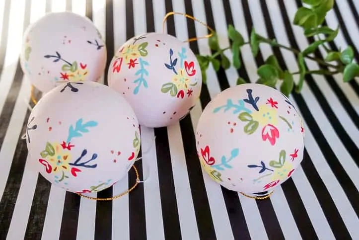 Make your own hand painted floral ornaments. This easy technique works for non-artists too. #decoartprojects #christmasornaments #diychristmasdecor #handpaintedflorals