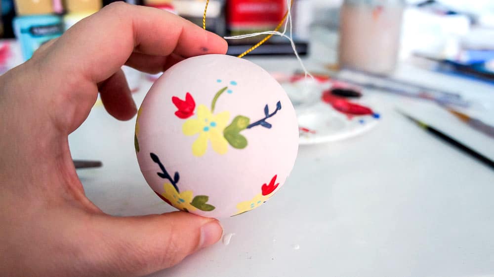 Make your own hand painted floral ornaments. This easy technique works for non-artists too. #decoartprojects #christmasornaments #diychristmasdecor #handpaintedflorals