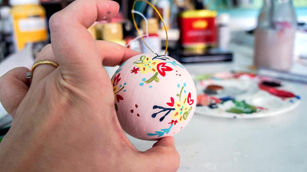 Make your own hand painted floral ornaments. This easy technique works for non-artists too. #decoartprojects #christmasornaments #diychristmasdecor #handpaintedflorals