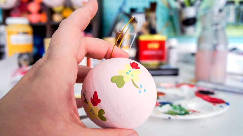 Make your own hand painted floral ornaments. This easy technique works for non-artists too. #decoartprojects #christmasornaments #diychristmasdecor #handpaintedflorals