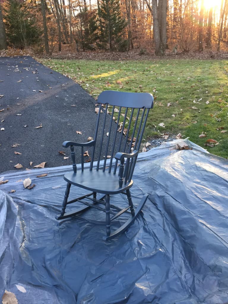spraying a rocking chair with a paint sprayer