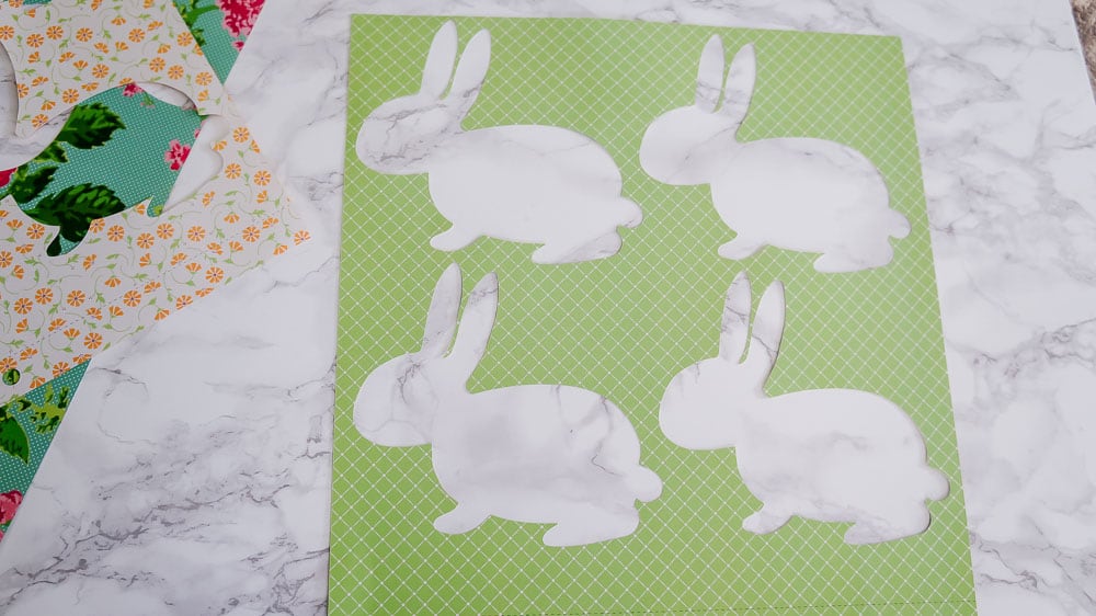 Need an easy spring project? This DIY Easter banner is made with scrapbook paper and old book pages. It's an easy craft to bring in some spring color. #eastercrafts #easterbunny #cutfiles #papercrafting