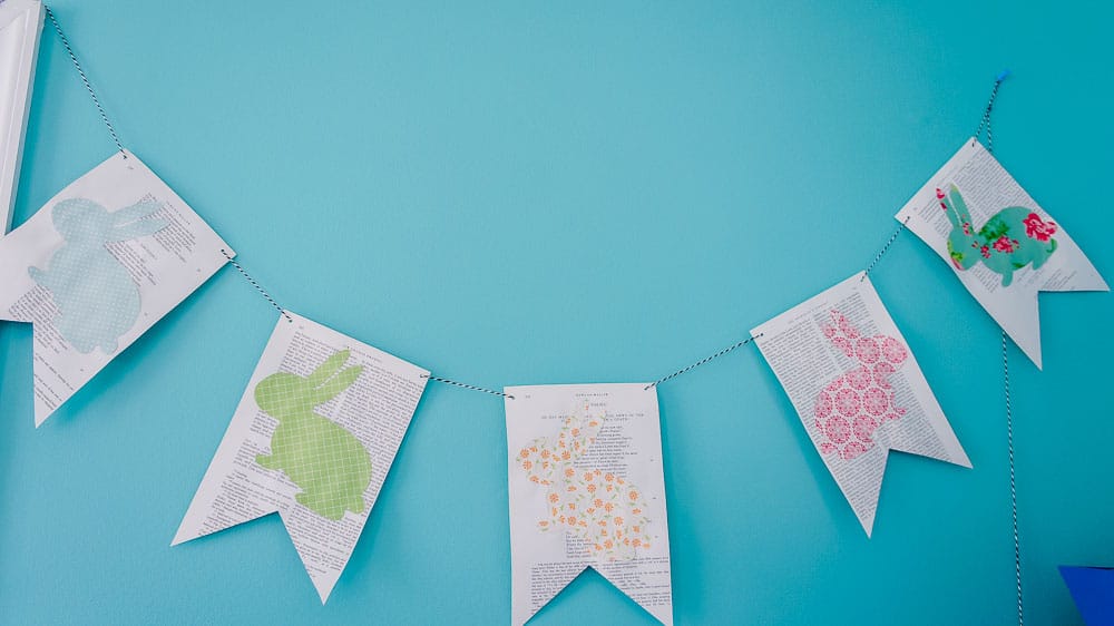 Need an easy spring project? This DIY Easter banner is made with scrapbook paper and old book pages. It's an easy craft to bring in some spring color. #eastercrafts #easterbunny #cutfiles #papercrafting