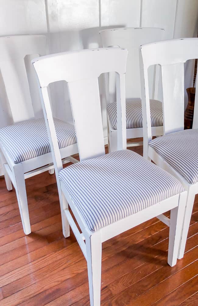 White distressed dining chairs with ticking upholstery