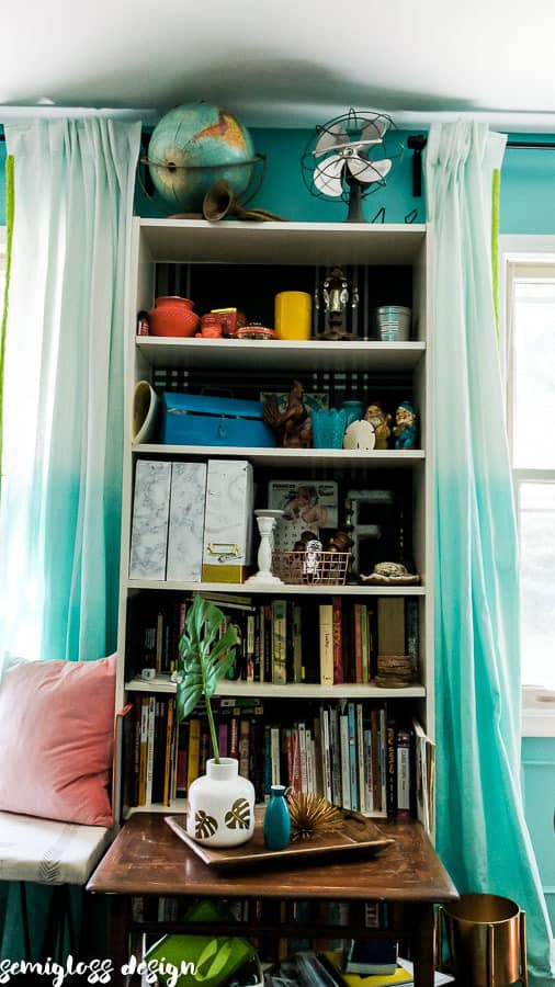 bookcase with plaid wallpaper and vintage collections