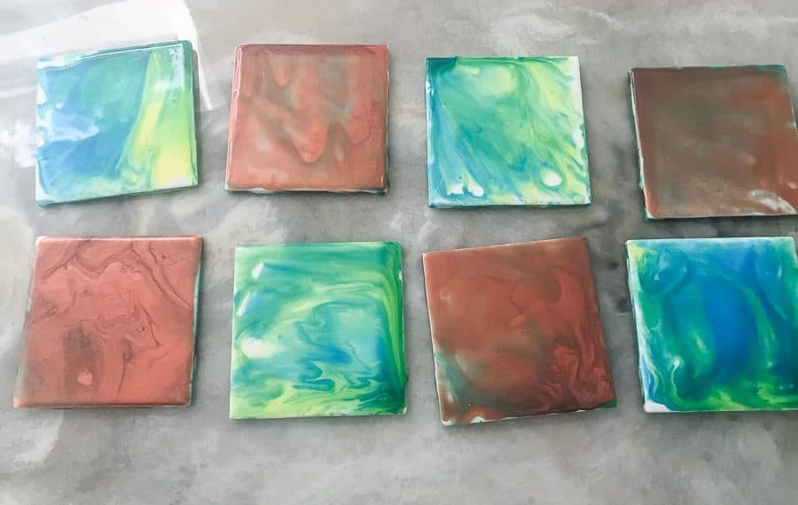 finished paint pour coasters in shades of blues and copper