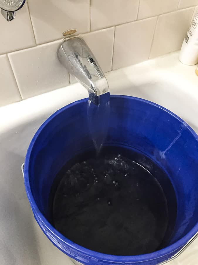 filling bucket with water for dye