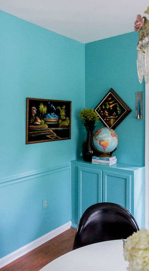 vintage art on teal walls with built in cabinets