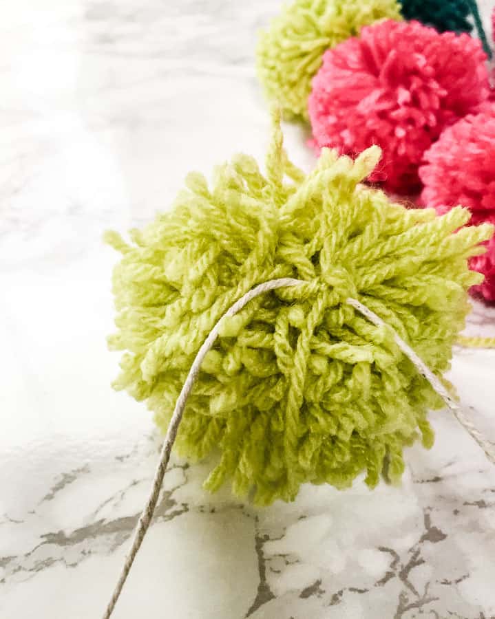 tie pom poms onto rope