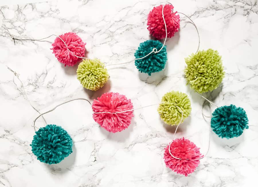 pom poms tied to twine to make garland