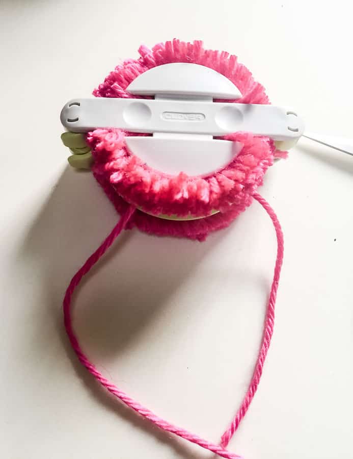 yarn tied around pom pom maker