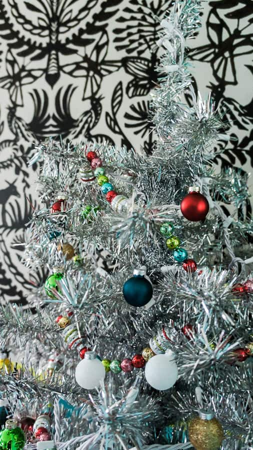 shiny bright ornaments on tinsel tree