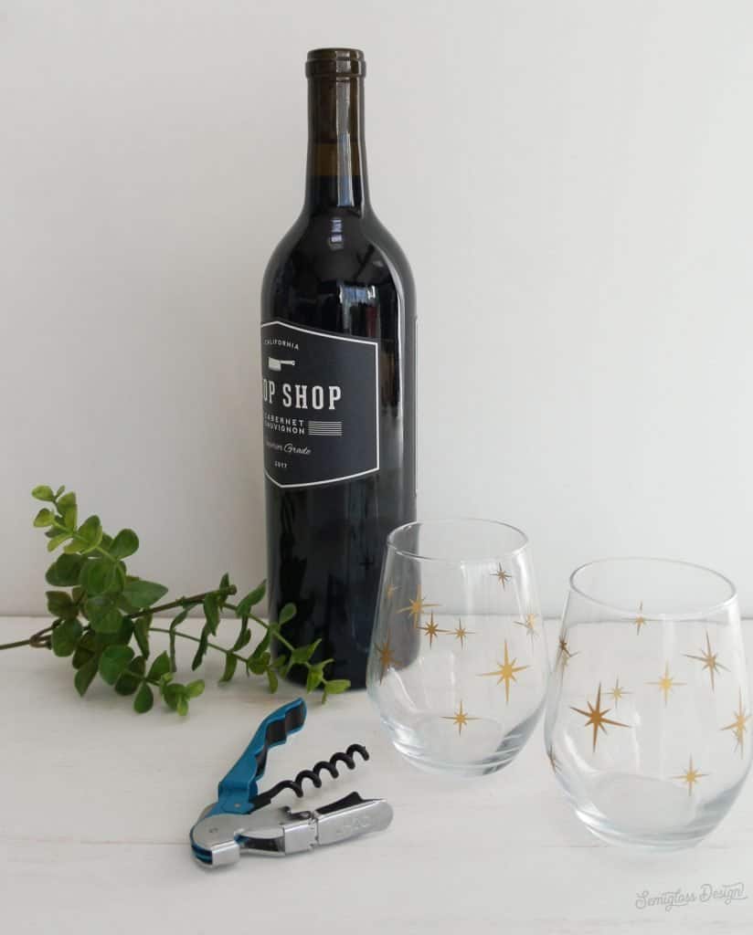 bottle of wine and wine glasses with gold starburst design