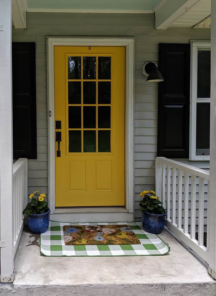 front porch makeover after with layered rugs and potted flowers