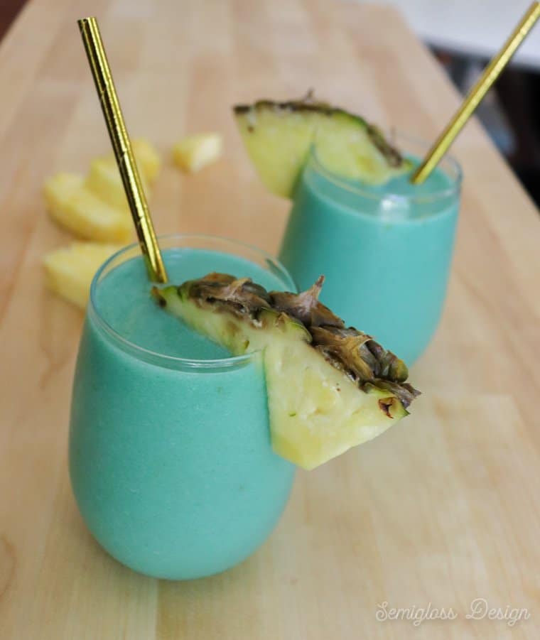 blue cocktails in glasses with pineapple garnish