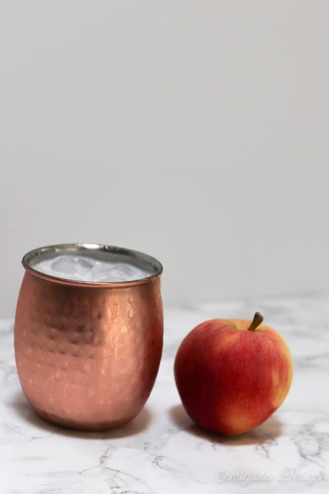 apple cocktail in copper mug with apple