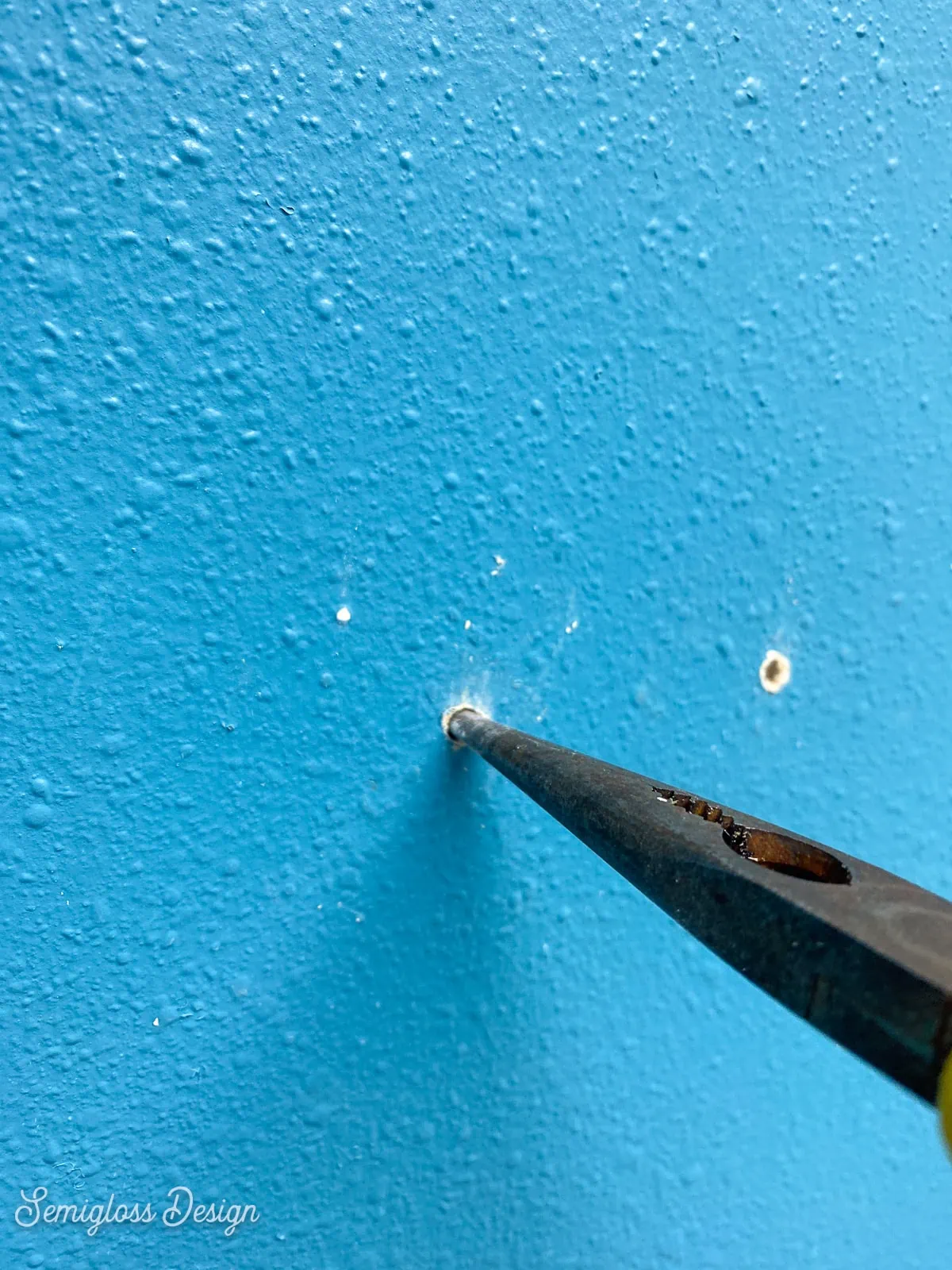 repairing nail hole with pliers