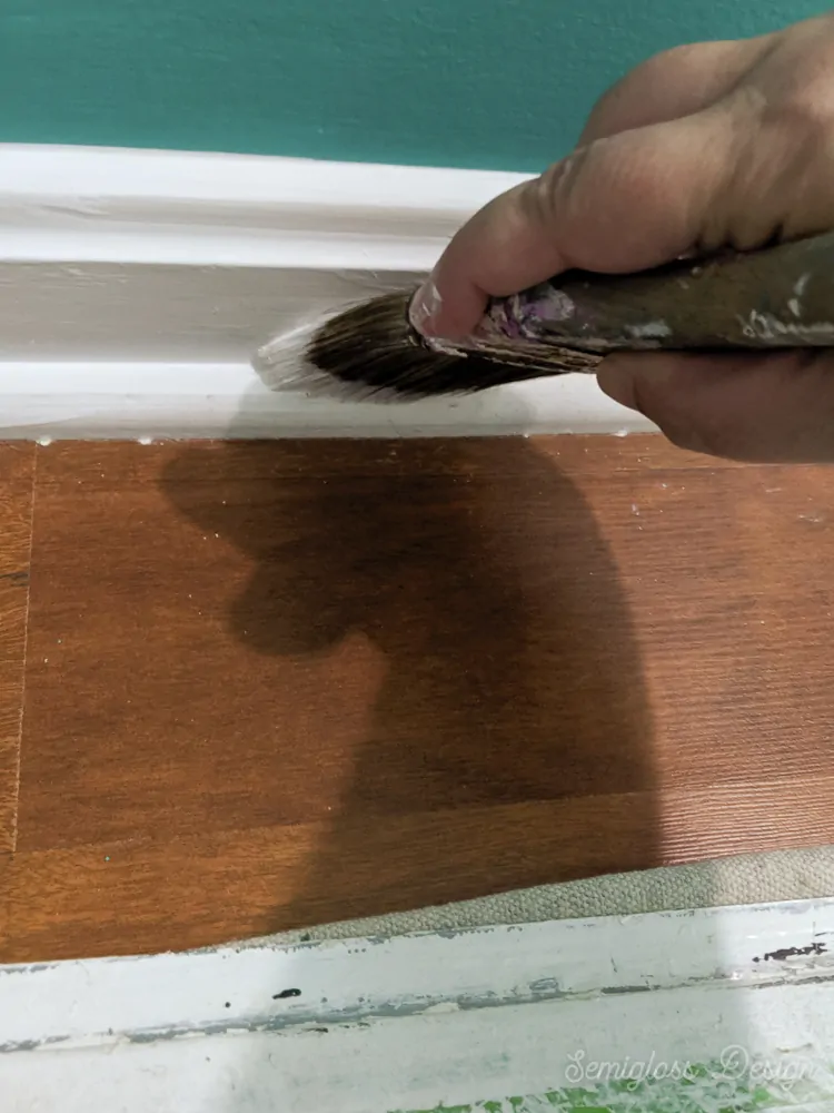 painting baseboard trim with paint brush