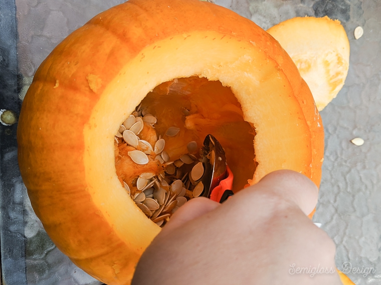 scooping seeds and pumpkin guts from pumpkin