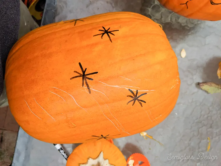 drawing designs with dry erase marker on pumpkin