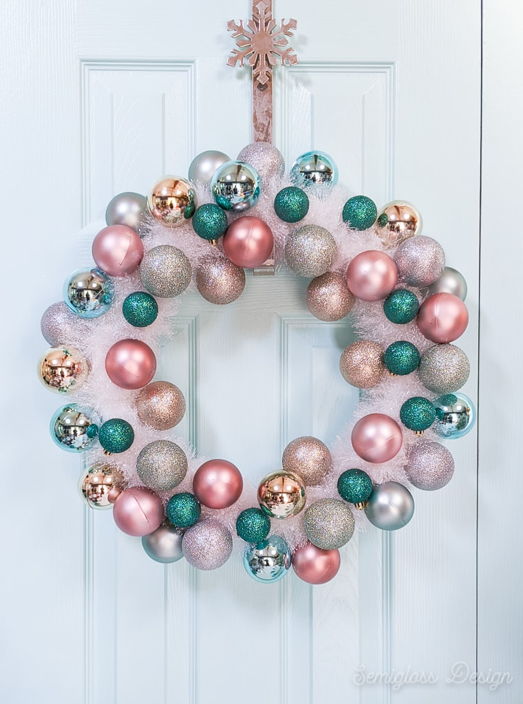 ornament and tinsel wreath on light blue door