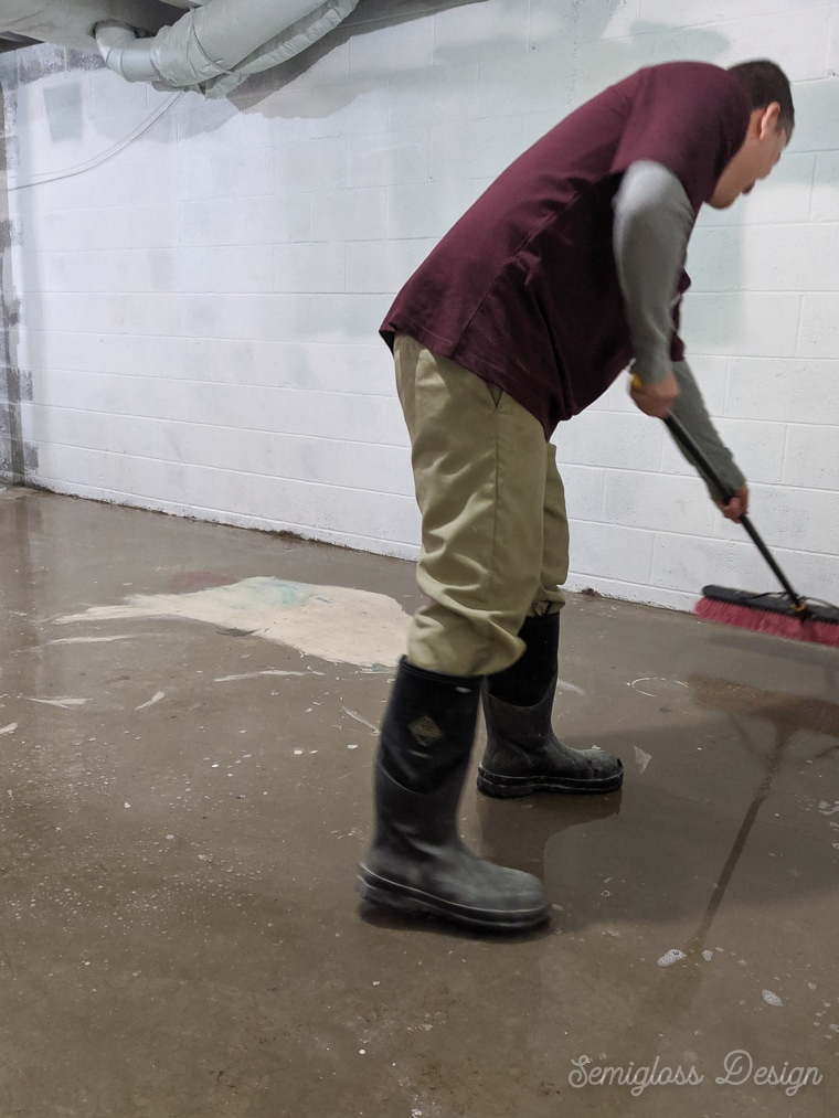 using push broom to scrub concrete floor