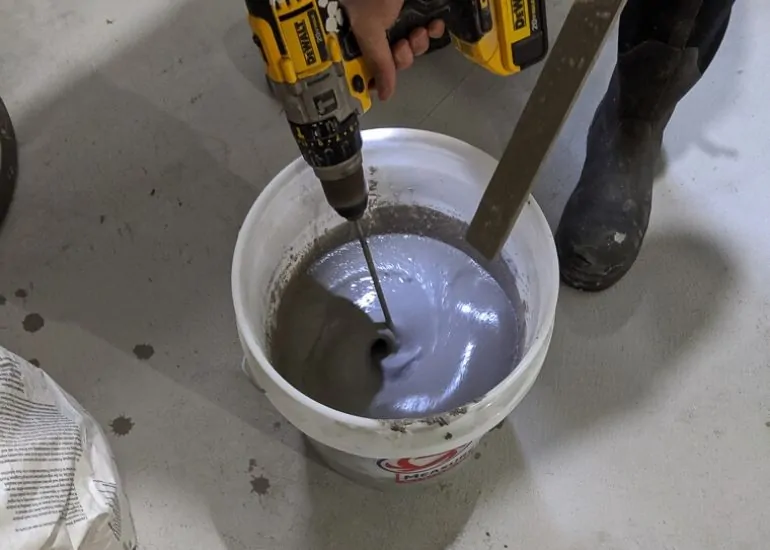 mixing concrete to refinish basement floor