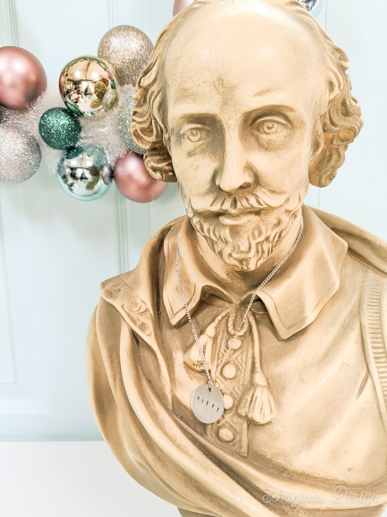stamped metal necklace on Shakespeare bust