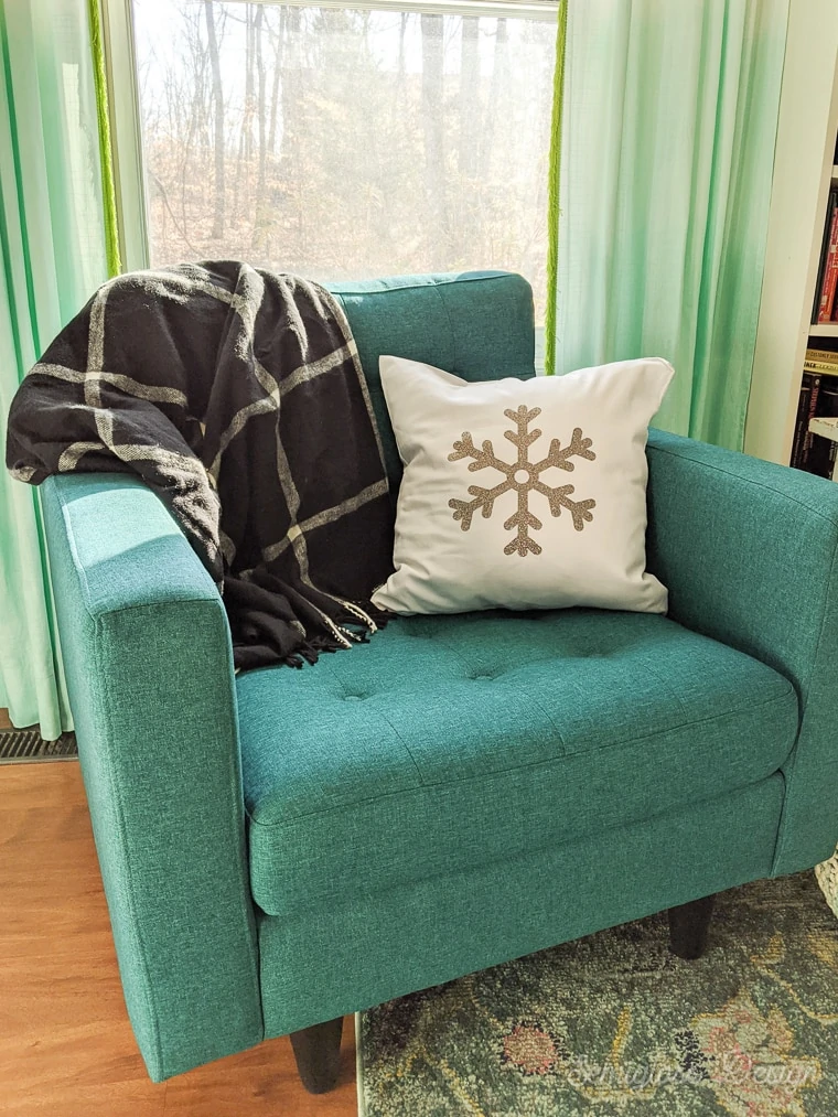 snowflake pillow and plaid throw on teal chair