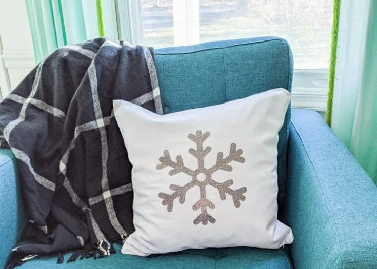 snowflake pillow on teal chair