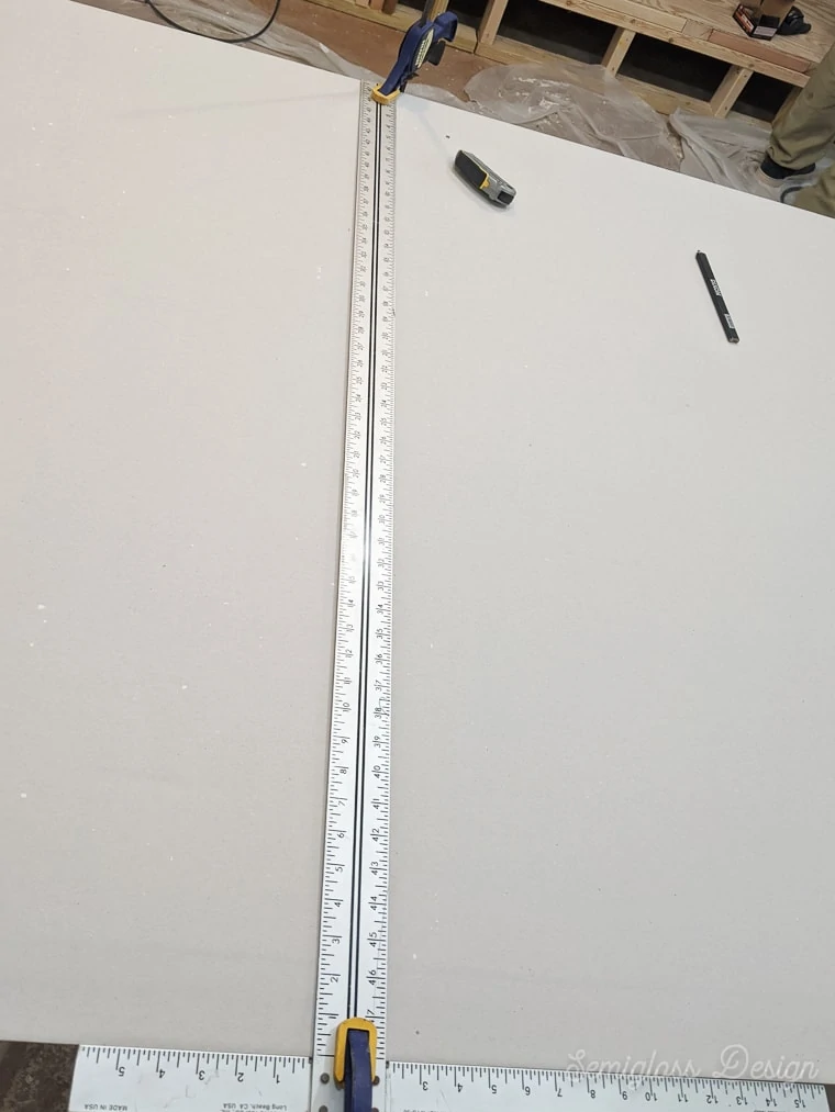 using a t-ruler to cut drywall