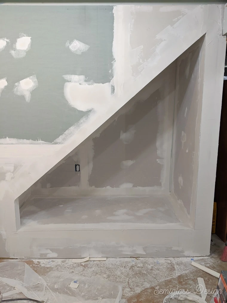 nook under stairs with drywall mudded and taped