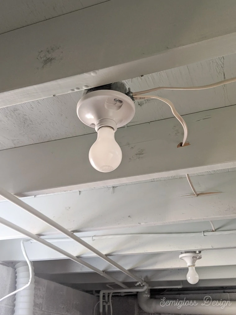 light fixture on exposed basement ceiling