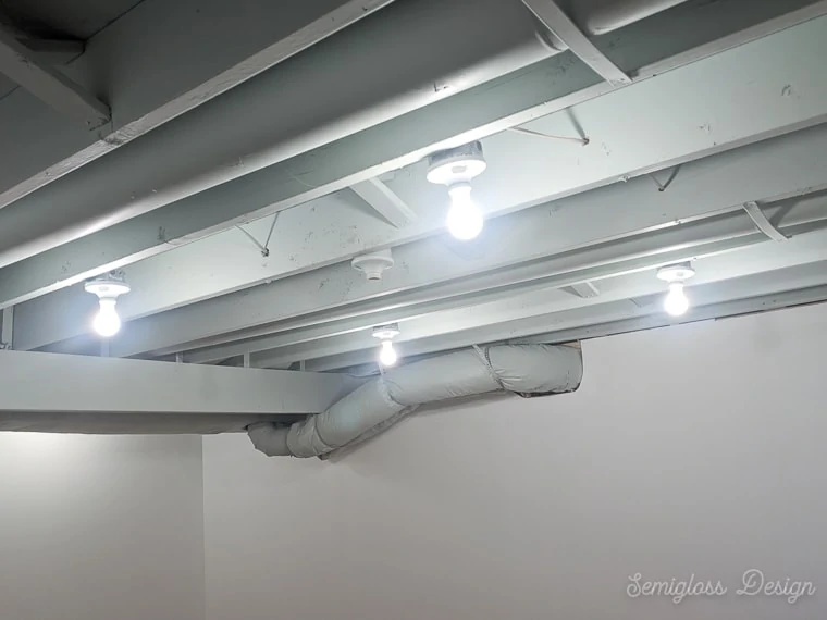 light fixtures in exposed basement ceiling