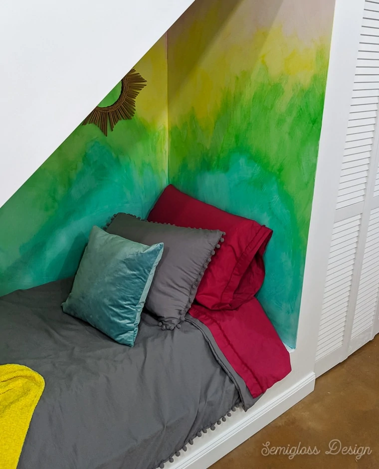 colorful nook with bed under stairs