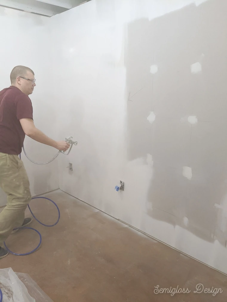 man spraying walls white