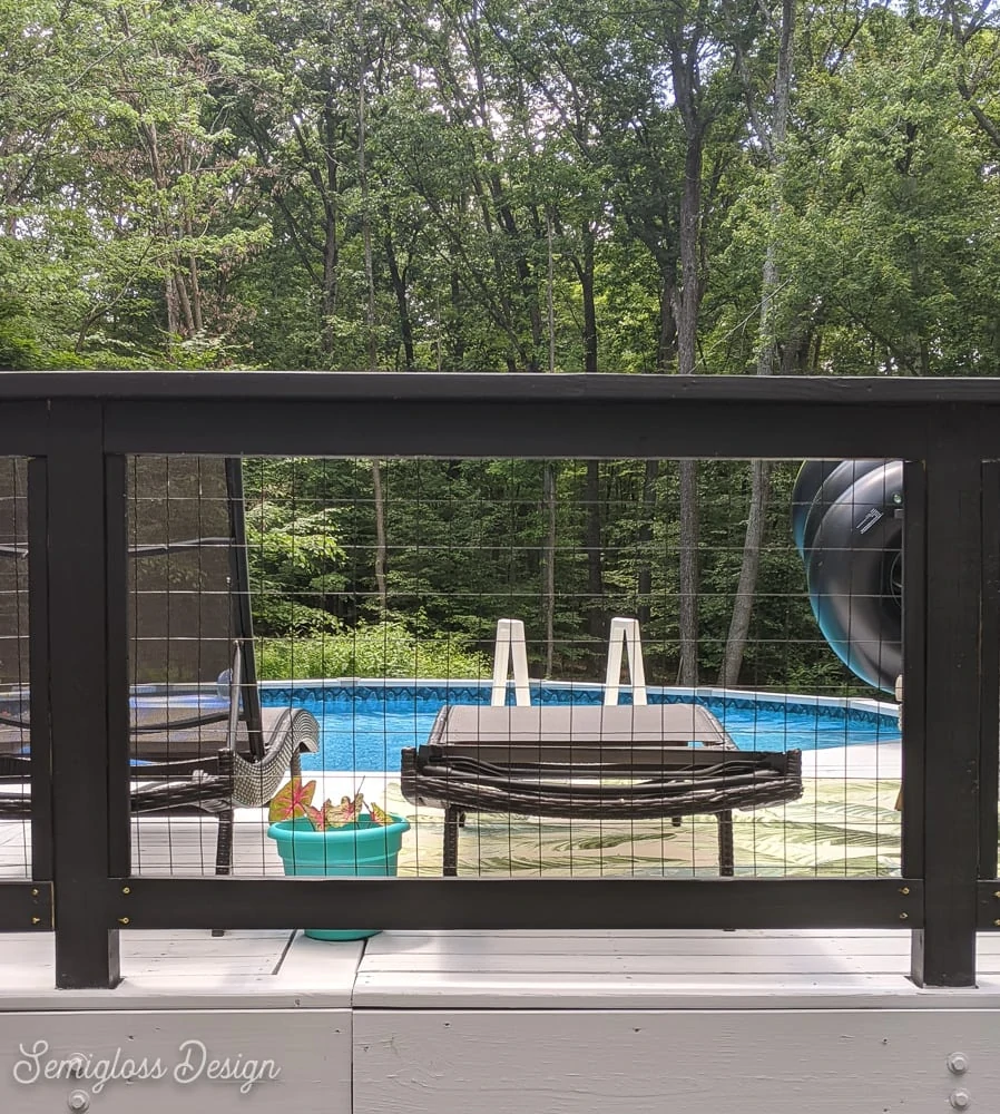 black modern railing on deck with pool in background