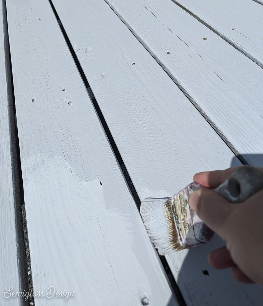 painting cracks of deck with paint brush