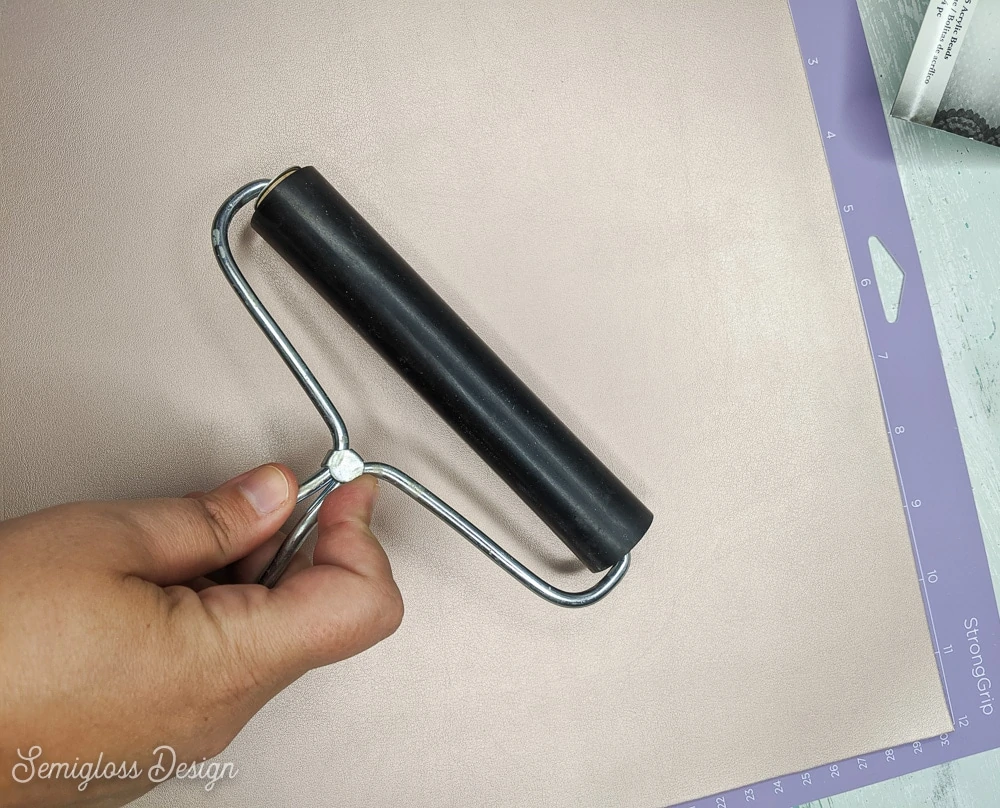 using a brayer to make leather stick to mat