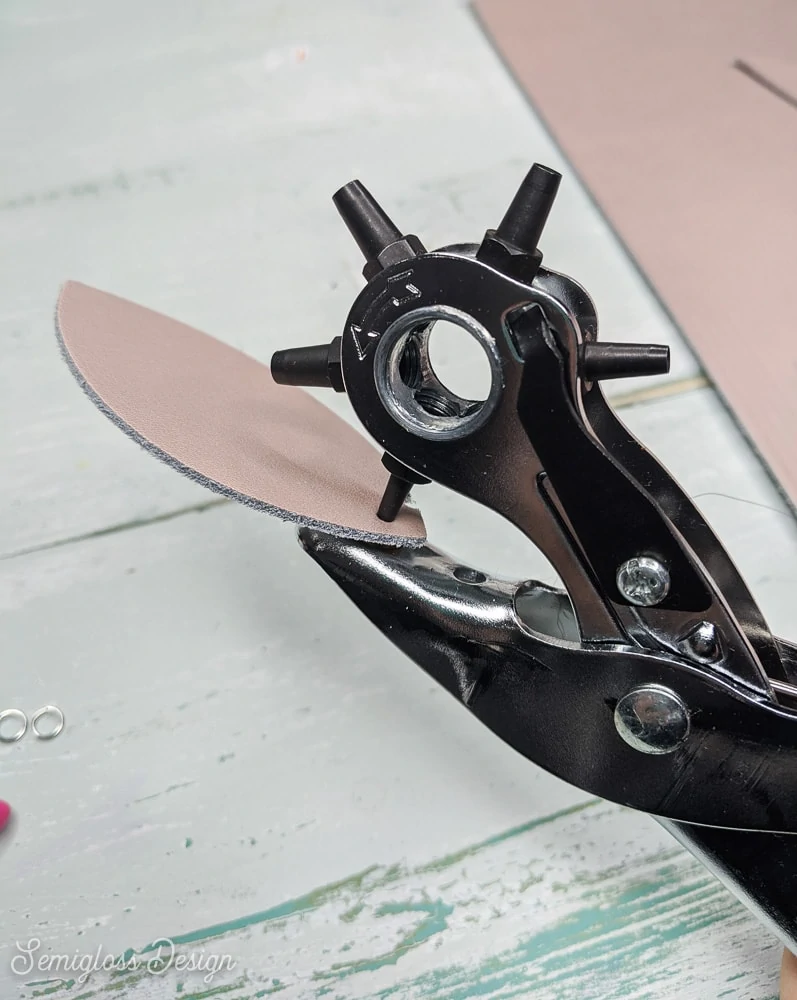 using a leather hole punch to make holes for earrings