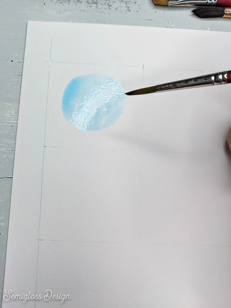 painting a blue circle with watercolor paint