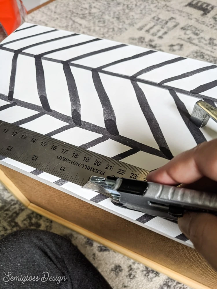 cutting edges of wallpaper with utility knife