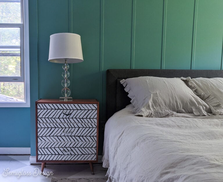 black and white pattern on dresser front in teal room with gray bed