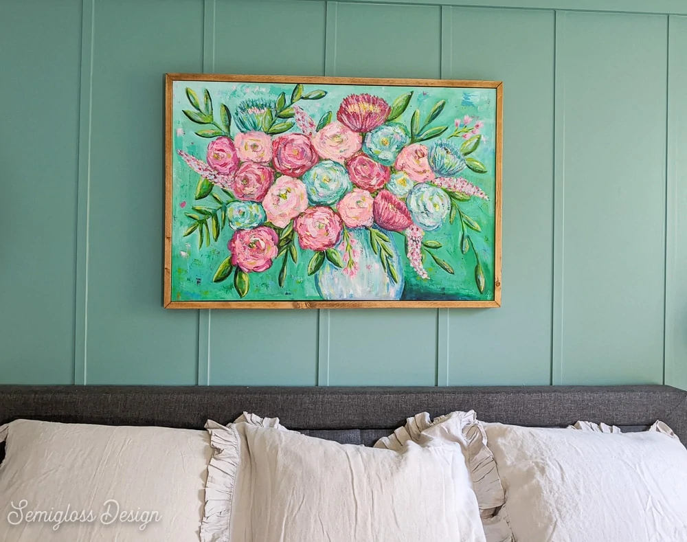 floral art on canvas with wood frame over gray bed